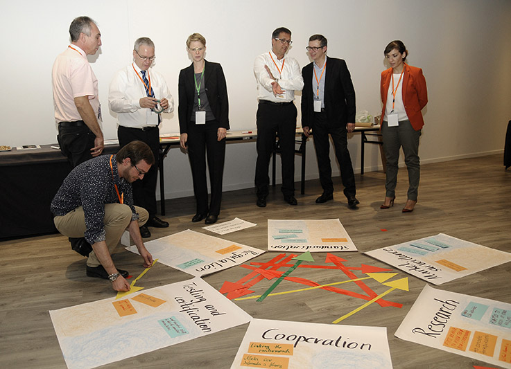 Workshop situation, seven people looking at some posters spread out on the floor