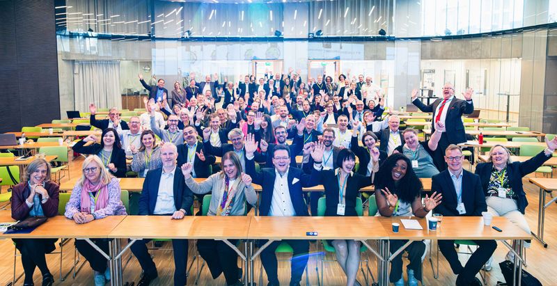 Group picture of cheering conference participants