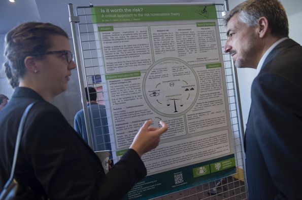 Conference delegates discussing in front of one of the displays in the poster exhibition